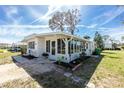 Well-maintained home exterior with an enclosed sunroom, landscaped yard, and a serene setting at 3220 Holly Ave, Englewood, FL 34224