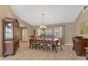 Elegant dining room featuring a chandelier, wood furniture, and natural light through large windows at 4050 Rock Creek Dr, Port Charlotte, FL 33948