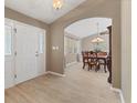 Inviting foyer with light tile flooring, a front door with sidelights, and arched entry to the dining room at 4050 Rock Creek Dr, Port Charlotte, FL 33948