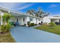 Charming exterior showcasing lush landscaping, blue accents, and covered parking for convenience and curb appeal at 414 Circlewood Dr # H2, Venice, FL 34293