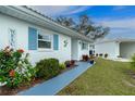 Close up of the well-maintained home showing manicured landscaping, a walkway, and vibrant blue window shutters at 414 Circlewood Dr # H2, Venice, FL 34293