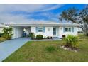 Charming single-story home with vibrant blue shutters, white exterior, and lush landscaping for curb appeal at 414 Circlewood Dr # H2, Venice, FL 34293