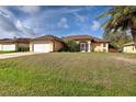 Charming one-story home with a well-manicured lawn, palm trees, and a two-car garage at 4966 Sunnyvale Rd, North Port, FL 34288