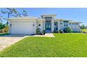 Beautiful single Gathering home with a well manicured lawn and a brick paved driveway and walkway at 5 Reef Ct, Placida, FL 33946
