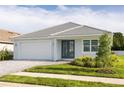 Beautiful single-story home with a well-maintained lawn, gray tile roof, and a brick paver driveway at 5213 Willow Lake Ct, Sarasota, FL 34233