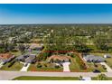 Aerial view showcasing the home nestled on a large lot with lush greenery and mature trees at 5441 Farley St, Port Charlotte, FL 33981