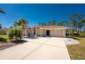 Well-maintained home featuring a spacious driveway and attached two-car garage, enhanced by palm trees at 5441 Farley St, Port Charlotte, FL 33981