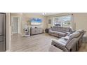 Sun-filled living room showcasing modern flooring, a large window with a view, and comfortable seating at 6264 Drucker Cir, Port Charlotte, FL 33981
