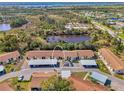 Aerial view of condo complex with covered parking near a pond in a neighborhood setting at 6796 Gasparilla Pines Blvd # 40, Englewood, FL 34224