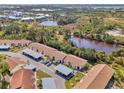 Aerial view of condo complex surrounded by landscaping with parking and a pond at 6796 Gasparilla Pines Blvd # 40, Englewood, FL 34224