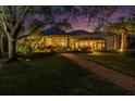 Backyard exterior with large, screened in porch, beautiful brick walkway, and large green lawn at twilight at 790 N River Rd, Venice, FL 34293