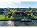 Beautiful waterfront home with a screened lanai, dock, and lush tropical landscaping at 8264 Antwerp Cir, Port Charlotte, FL 33981