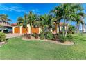 Charming home with a three-car garage, well-manicured lawn and tropical landscaping at 8264 Antwerp Cir, Port Charlotte, FL 33981