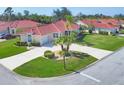 An elevated angle view of a charming home with a tile roof and well-manicured landscaping at 8356 Creekview Ln, Englewood, FL 34224