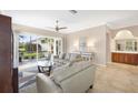 A well-lit living room showcases a ceiling fan, tile floors, and access to the screened lanai at 8356 Creekview Ln, Englewood, FL 34224