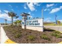 Palm Lake at Coco Bay community sign surrounded by beautiful landscaping and palm trees at 8562 Shore Lake Dr, Englewood, FL 34224
