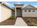 Inviting front entrance with landscaped walkway leading to a gray double door entry at 8562 Shore Lake Dr, Englewood, FL 34224