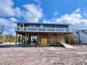 Quaint stilt home offering an outdoor shower and shaded space, perfect for relaxing near the beach at 8694 Marsh St, Placida, FL 33946