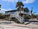 Beautiful raised beach house featuring an outdoor staircase, offering stunning views and coastal charm at 8694 Marsh St, Placida, FL 33946