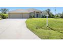 Charming single-story home featuring a three-car garage and well-manicured lawn at 9087 Hilliard Ter, Englewood, FL 34224
