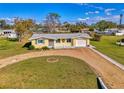 Overhead view of a yellow single-story home with a gravel driveway and a well-kept lawn at 91 Beverly Cir, Englewood, FL 34223