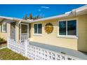 View of the home's front entrance and porch with decorative sun ornament at 91 Beverly Cir, Englewood, FL 34223