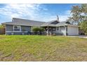 Charming single Gathering home featuring an attached garage and well-manicured lawn at 9341 Oceanspray Blvd, Englewood, FL 34224