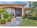Inviting front entrance with a decorative glass door surrounded by lush landscaping at 9460 Migue Cir, Port Charlotte, FL 33981