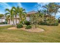 Beautifully landscaped front yard featuring palm trees and decorative stone beds at 9460 Migue Cir, Port Charlotte, FL 33981