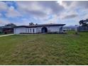 A well-kept home and yard featuring an attached garage and distinct architectural design at 1247 Price Nw Cir, Port Charlotte, FL 33948