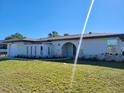 An angled view of a home featuring a well-manicured lawn and distinct facade at 1247 Price Nw Cir, Port Charlotte, FL 33948