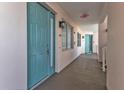 Hallway with teal doors, neutral walls, and access to residences in a condominium building at 13313 Gasparilla Rd # 404, Placida, FL 33946