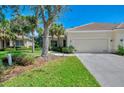 Charming single-story home with lush landscaping, a well-maintained lawn, and an attached garage at 14298 Reserve Ct, Port Charlotte, FL 33953