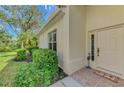 Inviting front entrance with a decorative door, tiled porch, and manicured landscaping at 14298 Reserve Ct, Port Charlotte, FL 33953