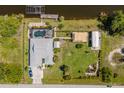 An aerial view showcasing the home's layout, pool, boat dock, and lush green surroundings at 14382 Lillian Cir, Port Charlotte, FL 33981