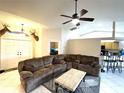 Spacious living room featuring a large sectional sofa, ceiling fan, and an open floor plan to the kitchen at 14399 Morristown Ave, Port Charlotte, FL 33981