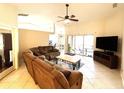 Open-concept living room boasts a large sectional sofa, ceiling fan, and sliding glass doors to the lanai at 14399 Morristown Ave, Port Charlotte, FL 33981