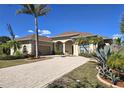 Charming home with a brick driveway, well-manicured landscaping, and a three-car garage at 14970 Appleton Blvd, Port Charlotte, FL 33981