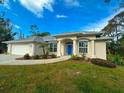 Charming single-story home featuring a bright blue front door and well-manicured lawn at 150 N Oxford Dr, Englewood, FL 34223