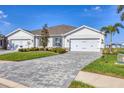 Well-maintained exterior showcasing a three-car garage and landscaped front yard at 16273 Coconut Palm Dr, Port Charlotte, FL 33953