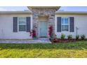 Charming front entryway with a stone accent wall and light blue front door at 16273 Coconut Palm Dr, Port Charlotte, FL 33953