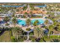 Aerial view of the community pool featuring palm trees, plenty of lounge chairs, and beautifully landscaped grounds at 19241 Serafina St, Venice, FL 34293