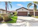 Inviting single-story home featuring a well-manicured lawn, mature landscaping, and a spacious driveway leading to a two-car garage at 19241 Serafina St, Venice, FL 34293
