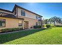 Well-maintained townhome exterior featuring lush green lawn and manicured shrubbery at 20110 Ragazza Cir # 102, Venice, FL 34293
