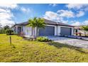 Attractive front exterior featuring a two-car garage, a well-kept lawn, and manicured landscaping at 2088 Bonito Way, Port Charlotte, FL 33953