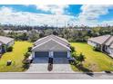 Charming front exterior of a home with a two-car garage, well-manicured lawn, and appealing landscaping at 2088 Bonito Way, Port Charlotte, FL 33953