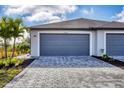 Two-car garage with paved driveway, well-maintained landscaping, and a modern exterior at 2088 Bonito Way, Port Charlotte, FL 33953