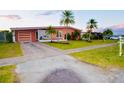 Inviting single-story home featuring a well-manicured lawn, mature landscaping, and a charming exterior at 22032 Felton Ave, Port Charlotte, FL 33952