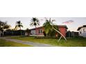 Lovely single-story home boasting mature palm trees, a green lawn, and a well-maintained exterior at 22032 Felton Ave, Port Charlotte, FL 33952