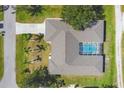 Aerial view of home featuring a private screened pool, well-maintained roof, and surrounding yard at 224 Pine Glen Ct, Englewood, FL 34223